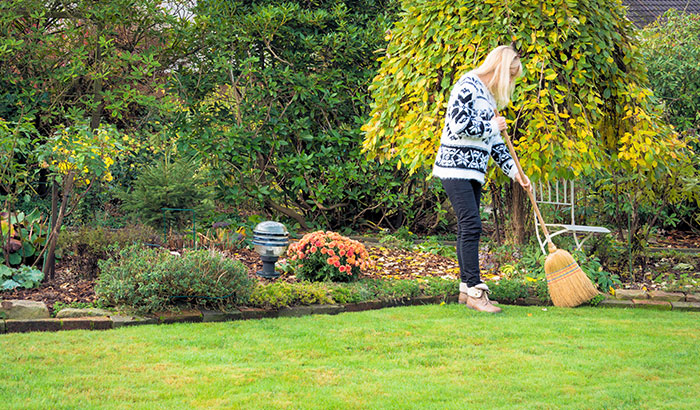 Woman raking leaves in garden