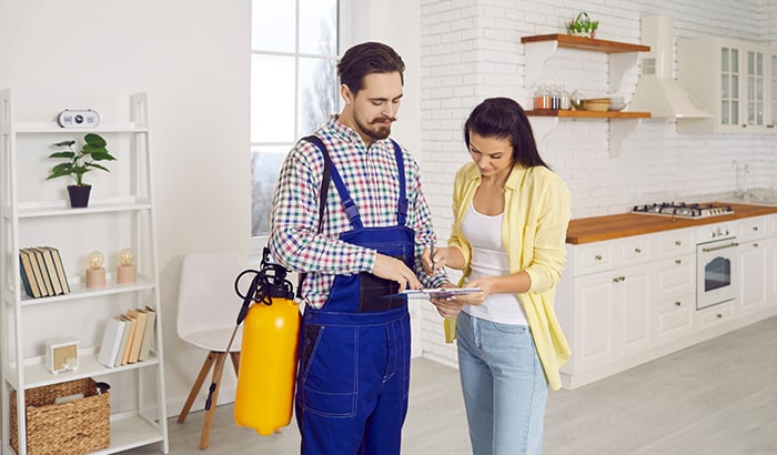 Pest control technician explaining service plan to homeowner